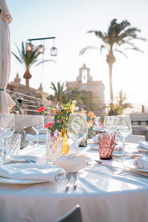 Terraza del Restaurante Catedral en Almería decorada para un evento al aire libre con flores y cristalería